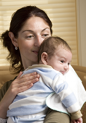 Woman holding baby over shoulder.