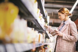 Woman in grocery store, looking at food items on a shelf