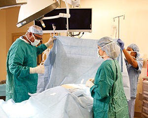 Healthcare providers performing surgery in operating room.