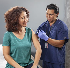 Proveedor de atención médica administrando una inyección en el brazo.
